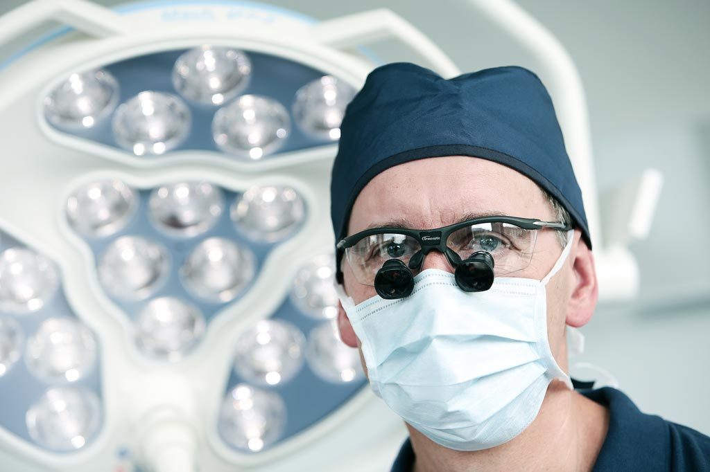 Dr. Spengler in OP-Kleidung und Lupenbrille-Brille